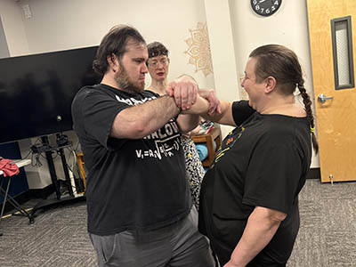 2 students practicing self defense techniques under watchful eye of the 1touch coach